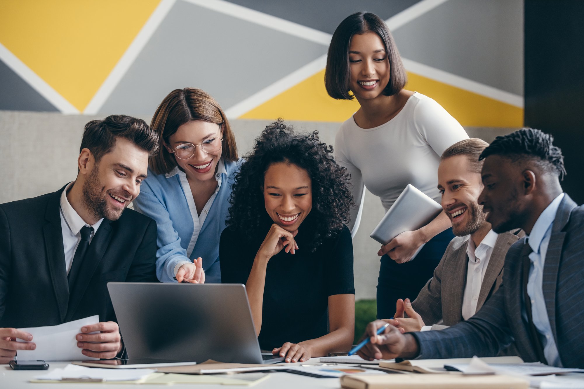 happy-young-business-team-looking-at-laptop-while-2024-01-22-19-08-18-utc